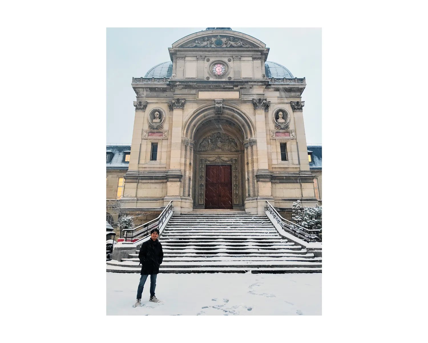 Standing in front of a snow-covered building facade in Paris